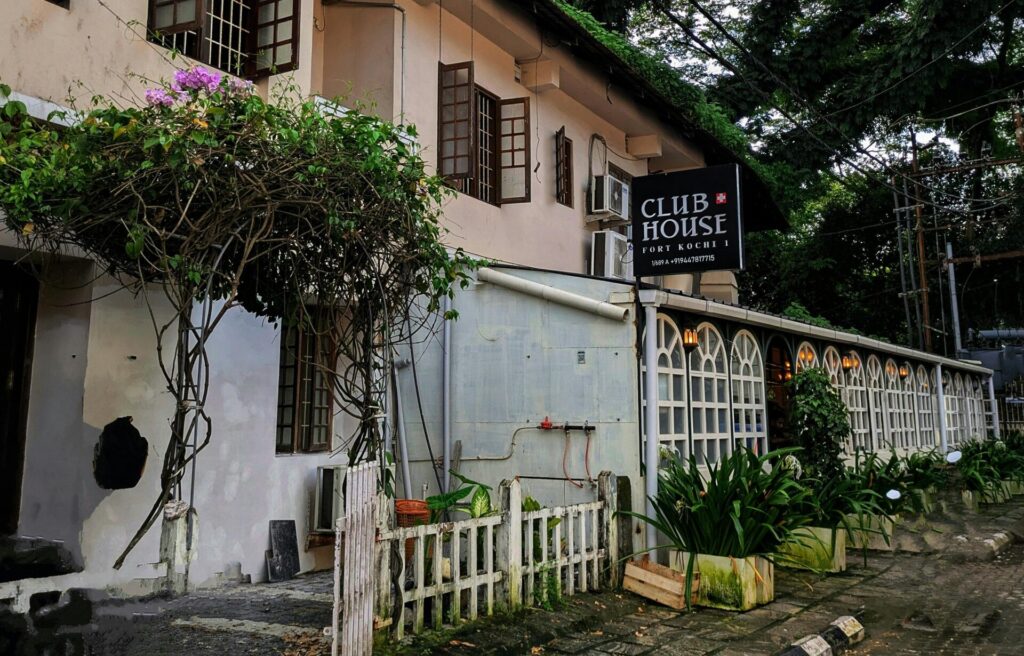 Exterior view of a quaint café surrounded by lush trees in Fort Kochi, Kerala, India.
